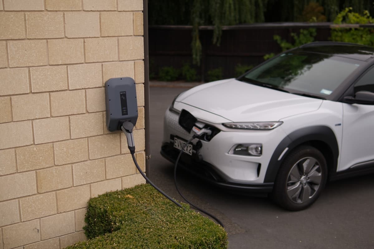 Wallbox doméstico en pared exterior cargando un coche eléctrico